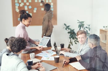 Team gathers at work for a meeting to discuss projects.